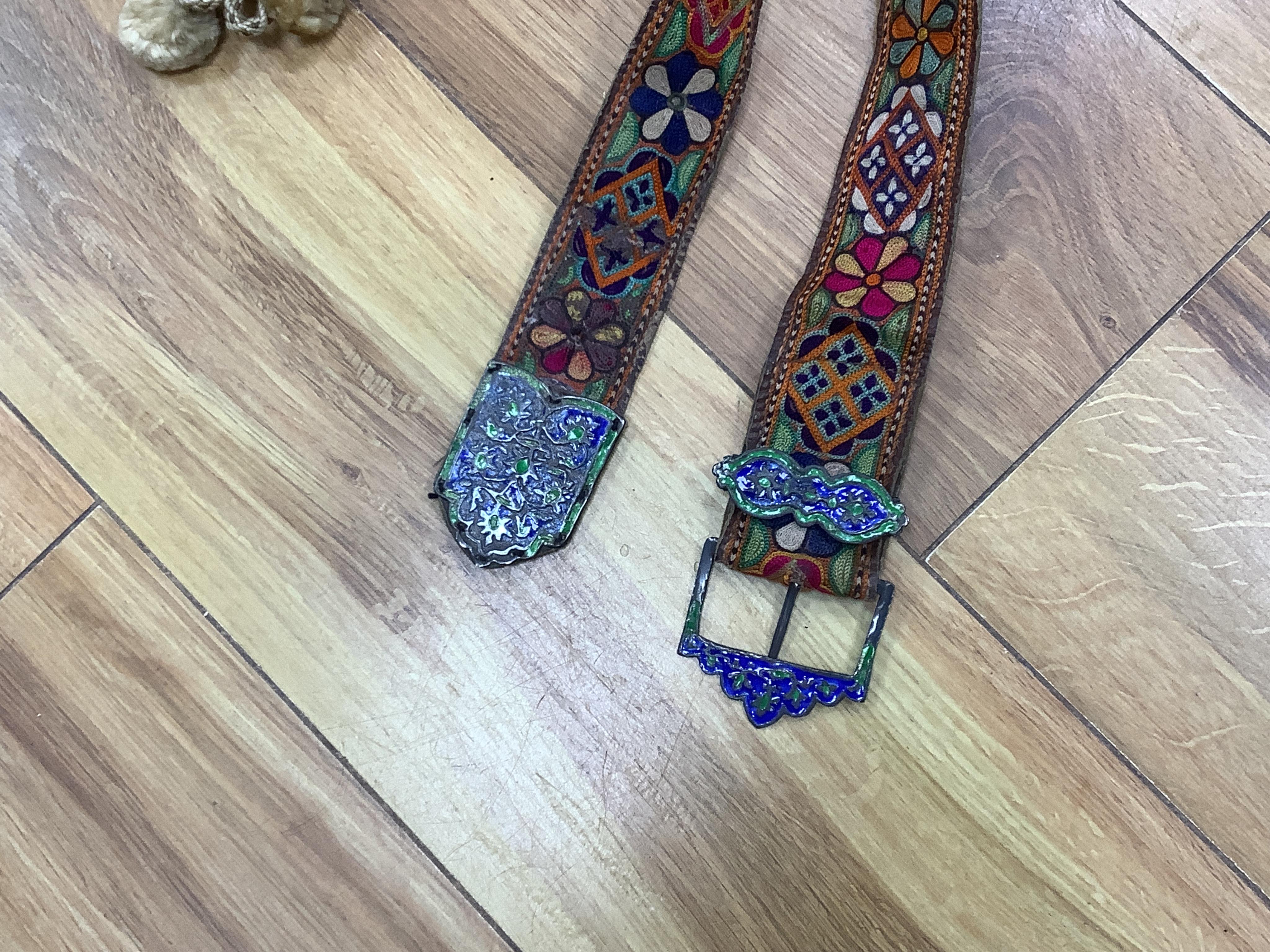 A collection of textiles: a ribbon work hankie and pyjama case, a metalwork collar, a coloured printed shawl, a nurses belt and embroidered belt, an advertising Guggenheim Bilbau hankie etc (10). Hankie case 22cm square.